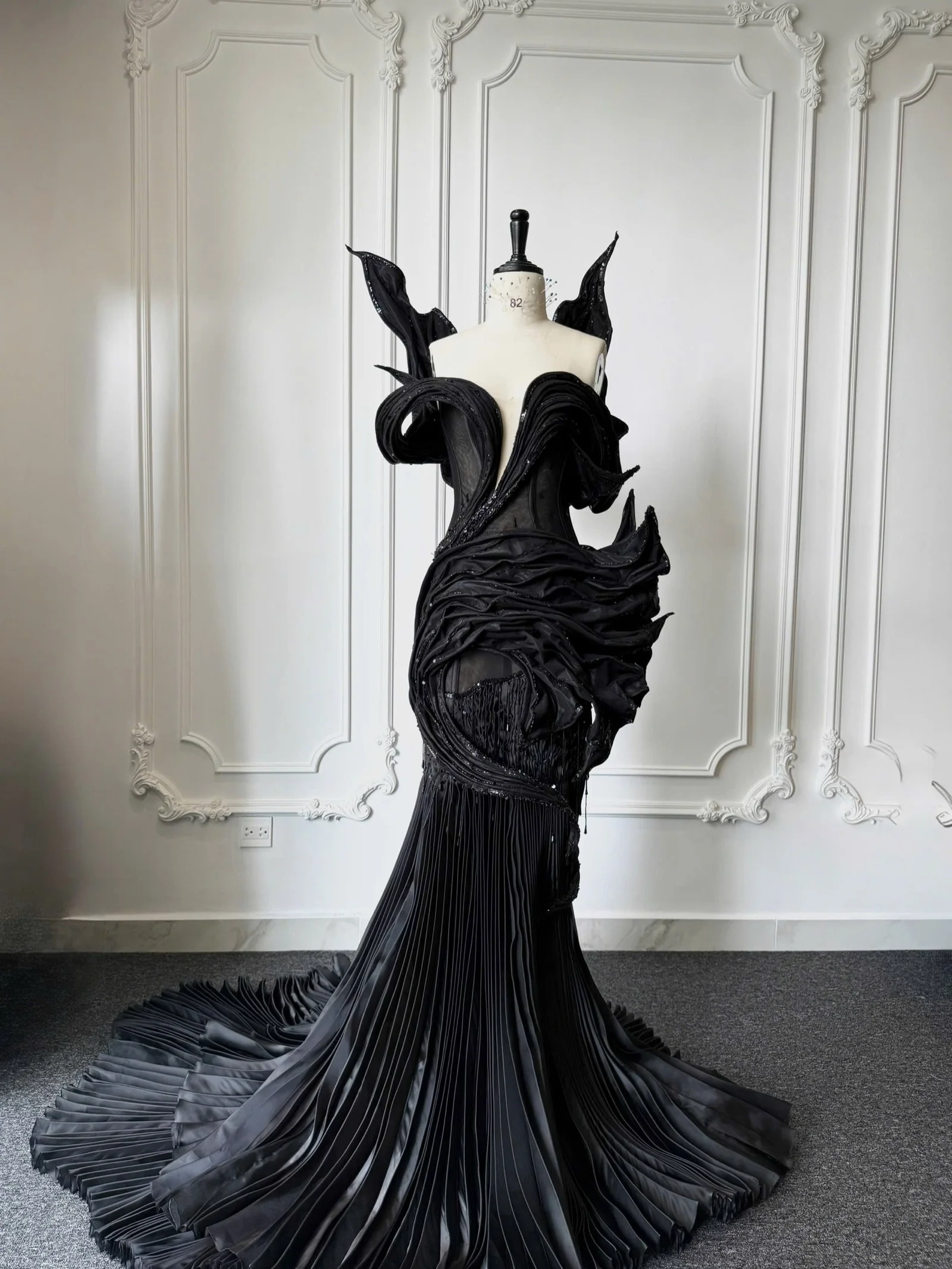 Black sculptural gown on form — structured construction reference